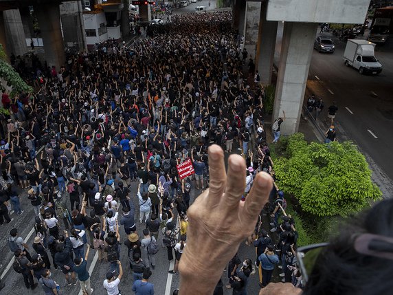 Des milliers de personnes ont levé trois doigts, un geste de résistance emprunté au film "Hunger Games". © KEYSTONE/AP/Gemunu Amarasinghe