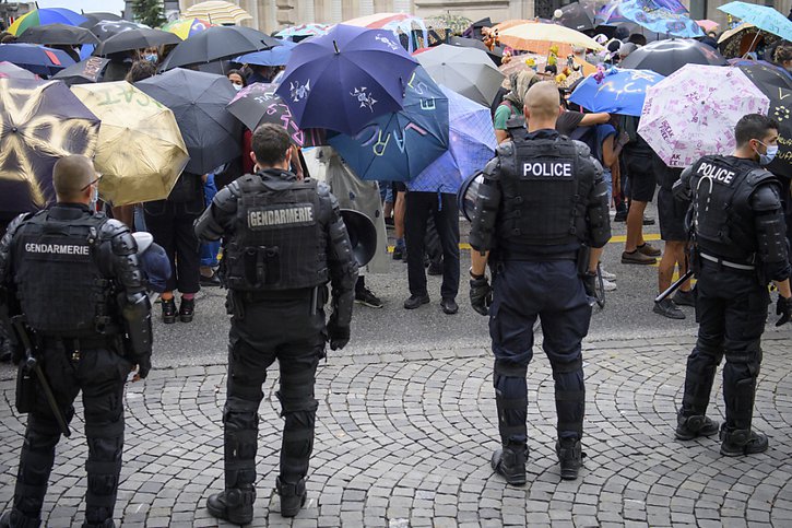 Des policiers en tenue anti-émeute ont encadré le cortège. © KEYSTONE/LAURENT GILLIERON