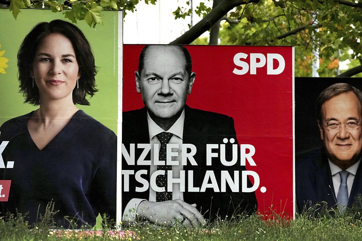 Le SPD d'Olaf Scholz (affiche du centre) devance légèrement, avec 25%, la CDU d'Armin Laschet (affiche de droite), créditée de 22 à 23% et les Verts d'Annalena Baerbock (17%). © KEYSTONE/AP/Michael Sohn