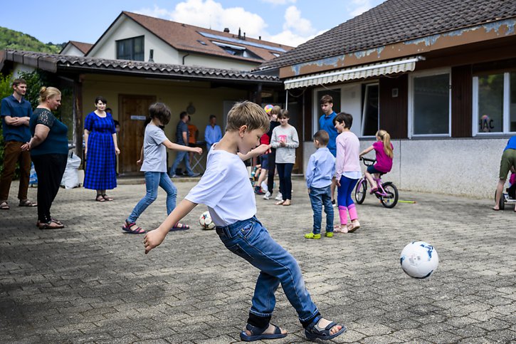 Des réfugiés jouent dans la cour de la maison qui les accueille à Gilly (VD). En tout, trois familles avec 25 enfants et cinq adultes sont accueillies dans ces lieux (archives). © KEYSTONE/JEAN-CHRISTOPHE BOTT