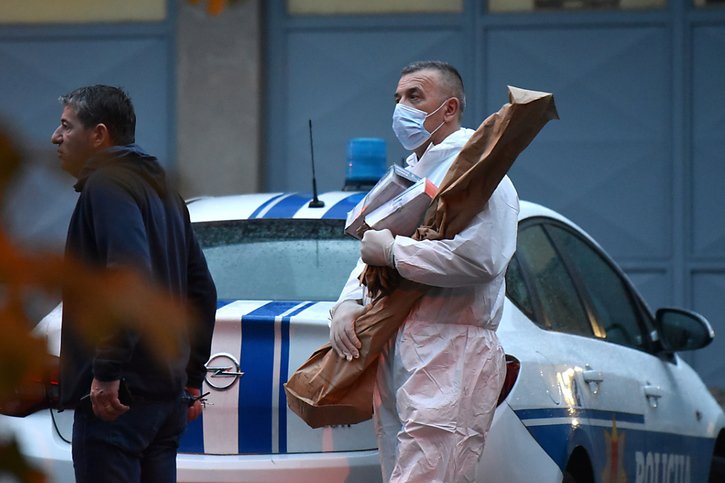 Un enquêteur forensique transporte une arme emballée, supposément celle du suspect. © KEYSTONE/EPA/BORIS PEJOVIC