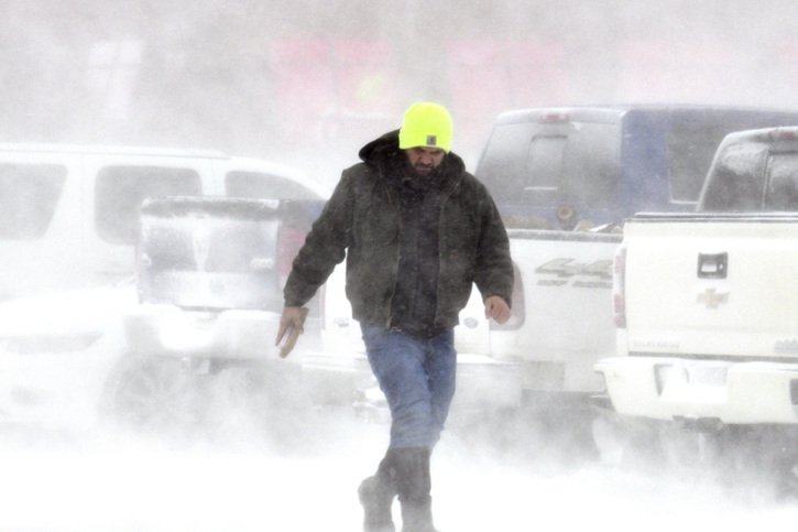Un homme tente de braver la tempête qui paralyse le pays depuis jeudi. © KEYSTONE/AP/Warren Dillaway