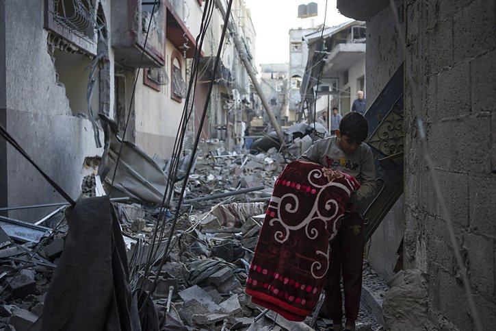 Un Palestinien regarde les maisons détruites par les bombardements israéliens à Rafah, dans le sud de la bande de Gaza, où la population a été poussée par Israël à se rendre. © KEYSTONE/AP/Fatima Shbair