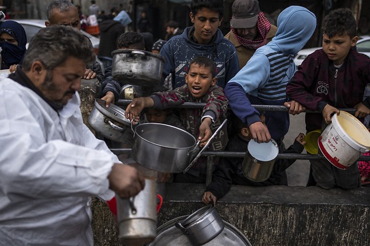 Des enfants palestiniens font la queue pour recevoir de la nourriture à Rafah, dans le sud de la bande de Gaza. © KEYSTONE/AP/Fatima Shbair
