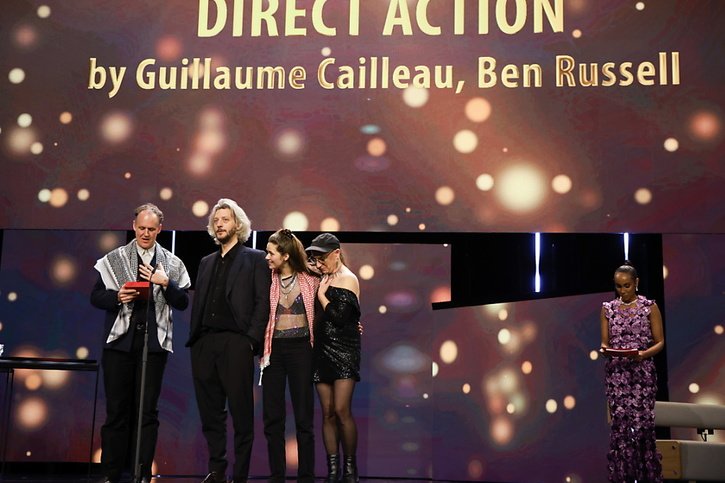 Parmi les cinéastes qui ont accusé Israël de génocide lors de la cérémonie de remise des prix de la Berlinale samedi soir figure l'Américain Ben Russell. Il s'exprime ici sur scène, portant un foulard palestinien. © KEYSTONE/EPA/CLEMENS BILAN