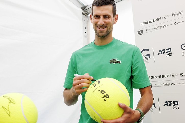 Novak Djokovic affiche un large sourire à l'heure de signer des autographes © KEYSTONE/SALVATORE DI NOLFI