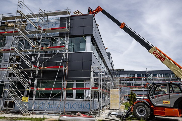 Des bâches recouvrent le chantier de l'entreprise Sellita Watch en reconstruction, une année après la tempête © Keystone/JEAN-CHRISTOPHE BOTT